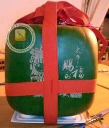 Квадратный арбуз а подарочной коробке с вырезанным пожеланием счастья. Таиланд.